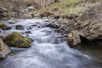 Fototapeta premium Long exposure of rapids of a small stream during winter