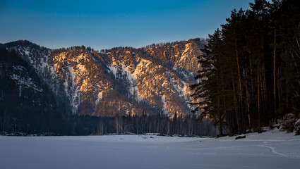 Fototapeta na wymiar Mountain landscape with a frozen river in winter Siberia background