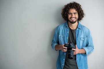 Happy male photographer standing in studio