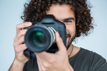 Male photographer with digital camera in studio - obrazy, fototapety, plakaty
