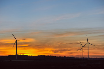 Silhouette of wind turbine on sunset