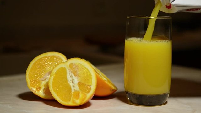 Pouring a glass of freshly squeezed orange juice from blender. Useful from fresh orange healthy food for breakfast, lunch and dinner.