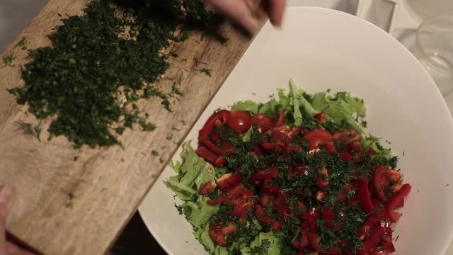 adding greens to salad
