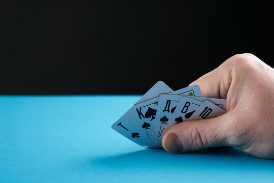 Hand of royal flush playing cards.Closeup.