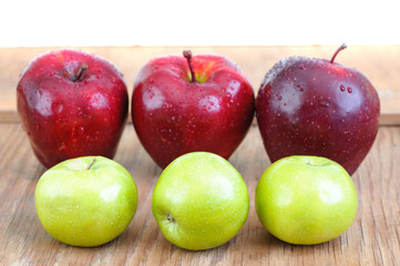 red and green apples lines on old wooden surface