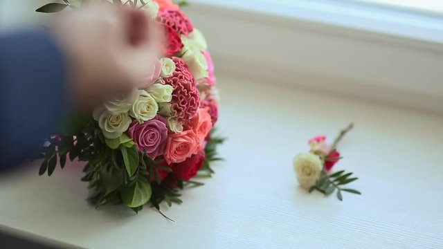Groom takes wedding rings and flowers for the bride. Preparation for the celebration. Close-up.