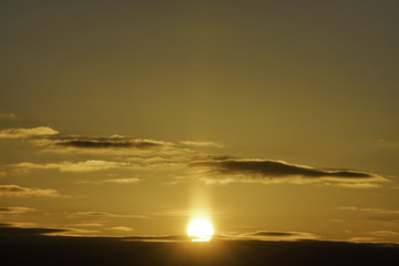 Fototapeta premium Golden sun rising above clouds, rays bursting