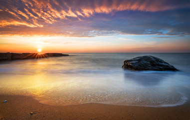 Early morning, sunrise over sea. Golden sands.