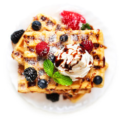 Belgian waffles with fresh berries and cream  isolated on white
