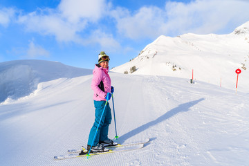 Young woman skier standing on ski slope in Obertauern, Austria