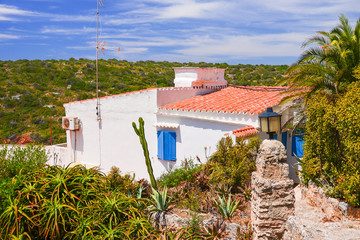 Traditional Spanish house in green landscape of Menorca island, Spain