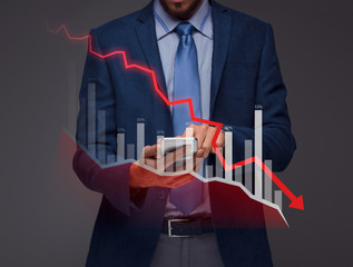 Businessman with chart in the fall, economy going down.