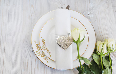 festive table setting with white roses and linen napkin top view