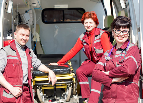 Paramedic professional female with coworker colleague near ambulance machine on background