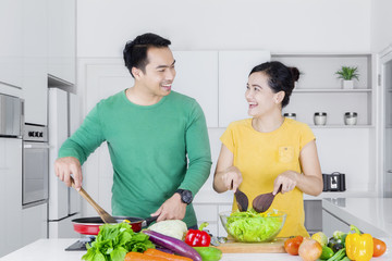 Cheerful woman and man cooking together