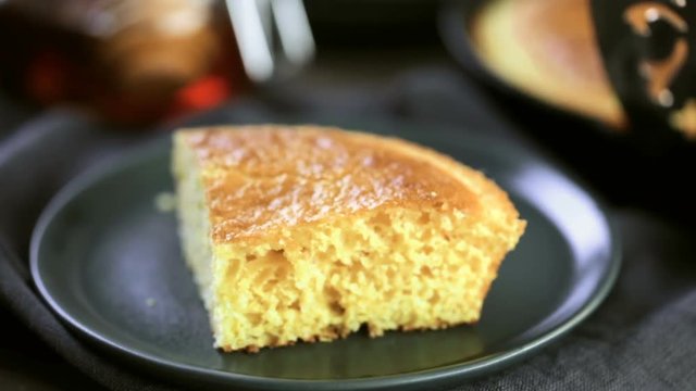 Slice of sweet cornbread with honey on the plate