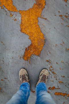 Man With Hiking Boots Standing on a Rusty Metallic Floor