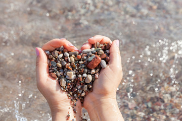 Fototapeta na wymiar Woman hands holding stones in heart shape