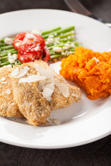 Parmesan Crusted Chicken Tenders with Roasted Sweet potato and Roasted Asparagus topped with Campari tomatoes, Feta Cheese, Olive oil, and salt macro shot 