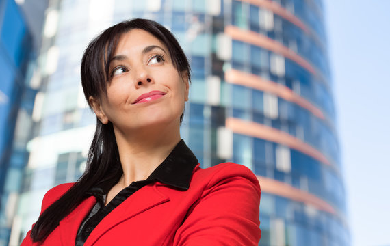 Portrait of a smiling business woman in front of a skyscraper
