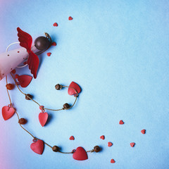 Levitating Angel with hearts and bells. Symbol of love. The concept  Valentine's Day. Blue background
