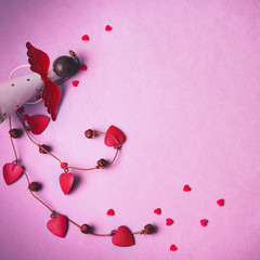 Levitating Angel with hearts and bells. Symbol of love. The concept  Valentine's Day. Pink background
