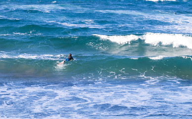 A surfer among the waves of the ocean.