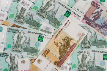 Fototapeta na wymiar The background of randomly scattered Russian banknotes of different denomination