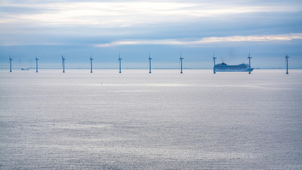 cruise liner near offshore wind farm in morning