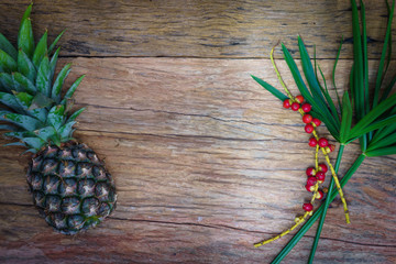 Pineapple, raw coffee beans and grass. on wooden rustic backgrou
