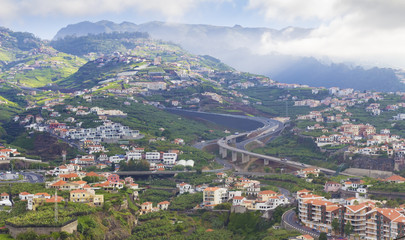 Fototapeta na wymiar typical landscape on Madeira island, houses on hills and road background, Portugal