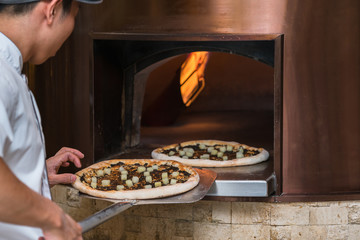 Pizza baking in traditional stone oven
