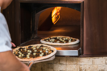 Pizza baking in traditional stone oven
