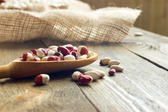 white beans on a wooden table and wooden spoon