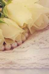 white fresh roses with lace and pearls, retro toned