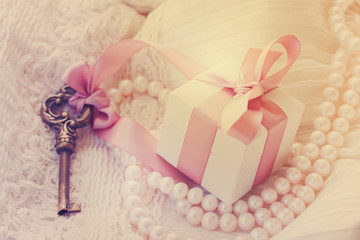 gift box and key with pearl jewellery and white lace, retro toned