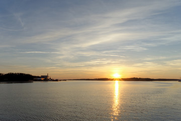 Fototapeta na wymiar A view of the calm golden sunset on the river with the sun reflected in it, Volga, Russia