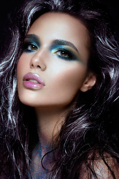 Beautyful girl with blue glitter on her face and body