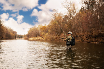 Fototapeta na wymiar Fisherman catches a trout on the river