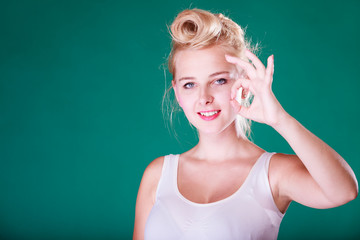 Smiling pin up girl making a ok gesture