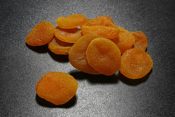 dried apricots on black shiny background