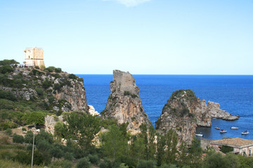Fototapeta na wymiar Top view of the rocks, medieval tower and Mediterranean ocean in Scopello Beach, Sicily, Italy