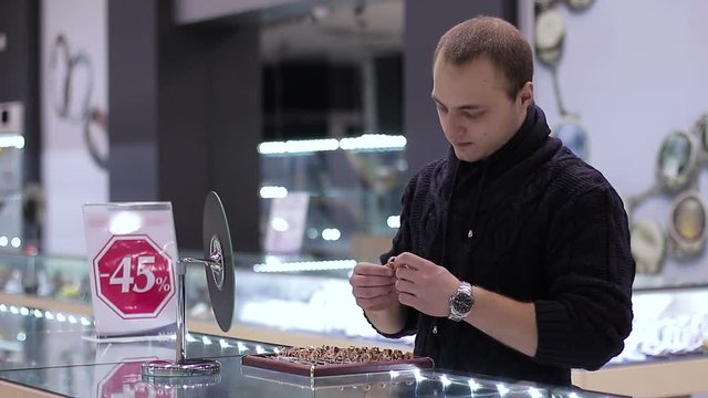 Jewelry store: Young Man tries on ring. Close up