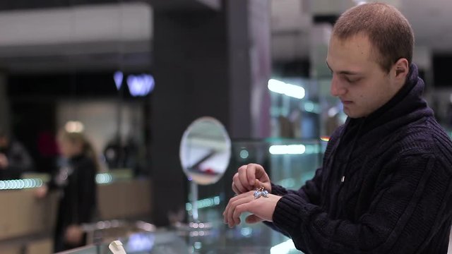 Jewelry store: Young guy chooses a girl earrings as a present