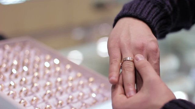 Jewelry store: Man tries on wedding ring. Close up