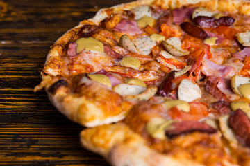 Close up of pizza with ham, sausages and mustard