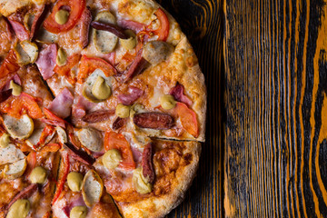 High angle view of half of delicious pizza with ham, tomatoes, s