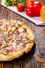 Close up of delicious pizza near are other vegetables on a napki