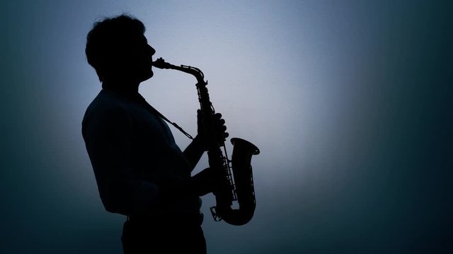 Saxophone player over a gray background. Real time.