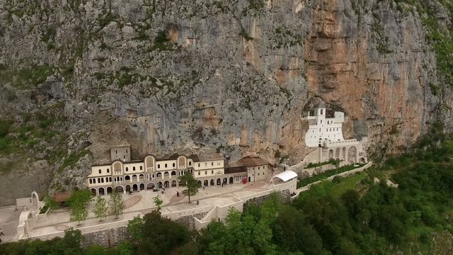 Flying in front of monastery of Ostrog in the large rock of Ostroska Greda, Montenegro. Aerial view
